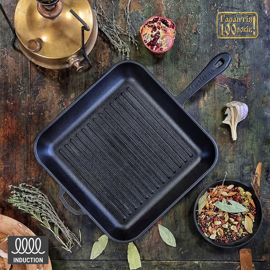 Black cast iron grill pan on a rustic wooden surface with herbs and spices.