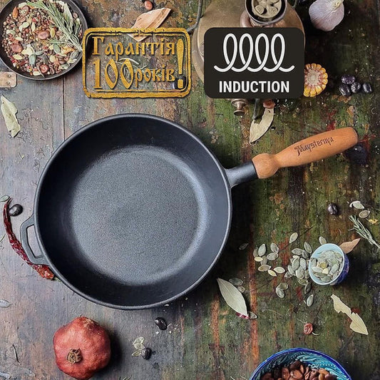 Black cast iron frying pan on a rustic wooden surface with decorative elements and branding.