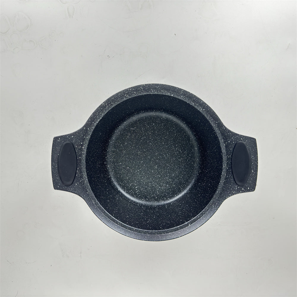 Black speckled cast iron skillet on a light gray background