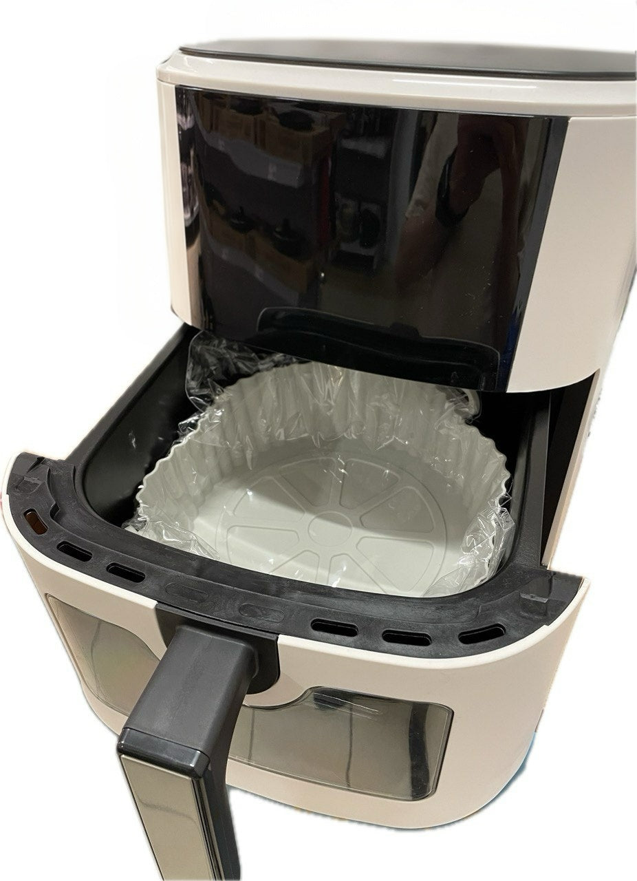 White air fryer with open door showing a clear basket on a white background