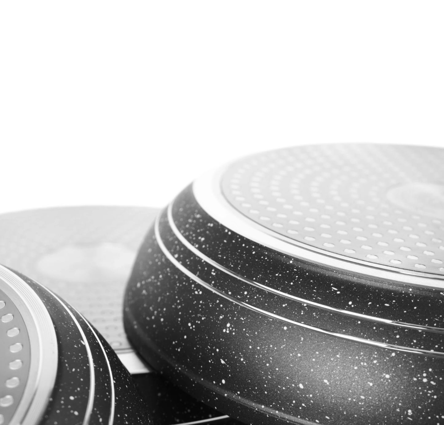 Close-up of a speckled black and white frying pan on a white background