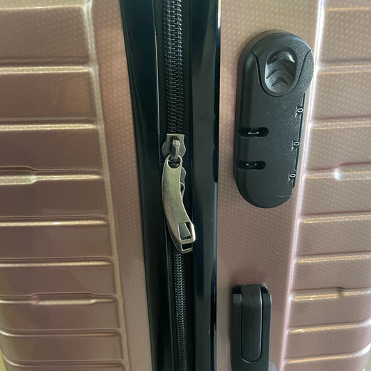 Close-up of a suitcase with a zipper and lock mechanism.