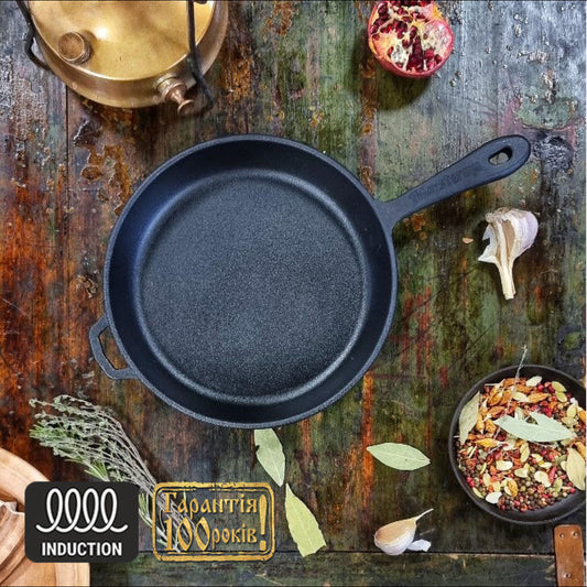 Black cast iron skillet on a rustic wooden surface with herbs and spices.
