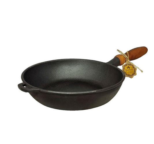 Black cast iron pan with a wooden handle on a white background