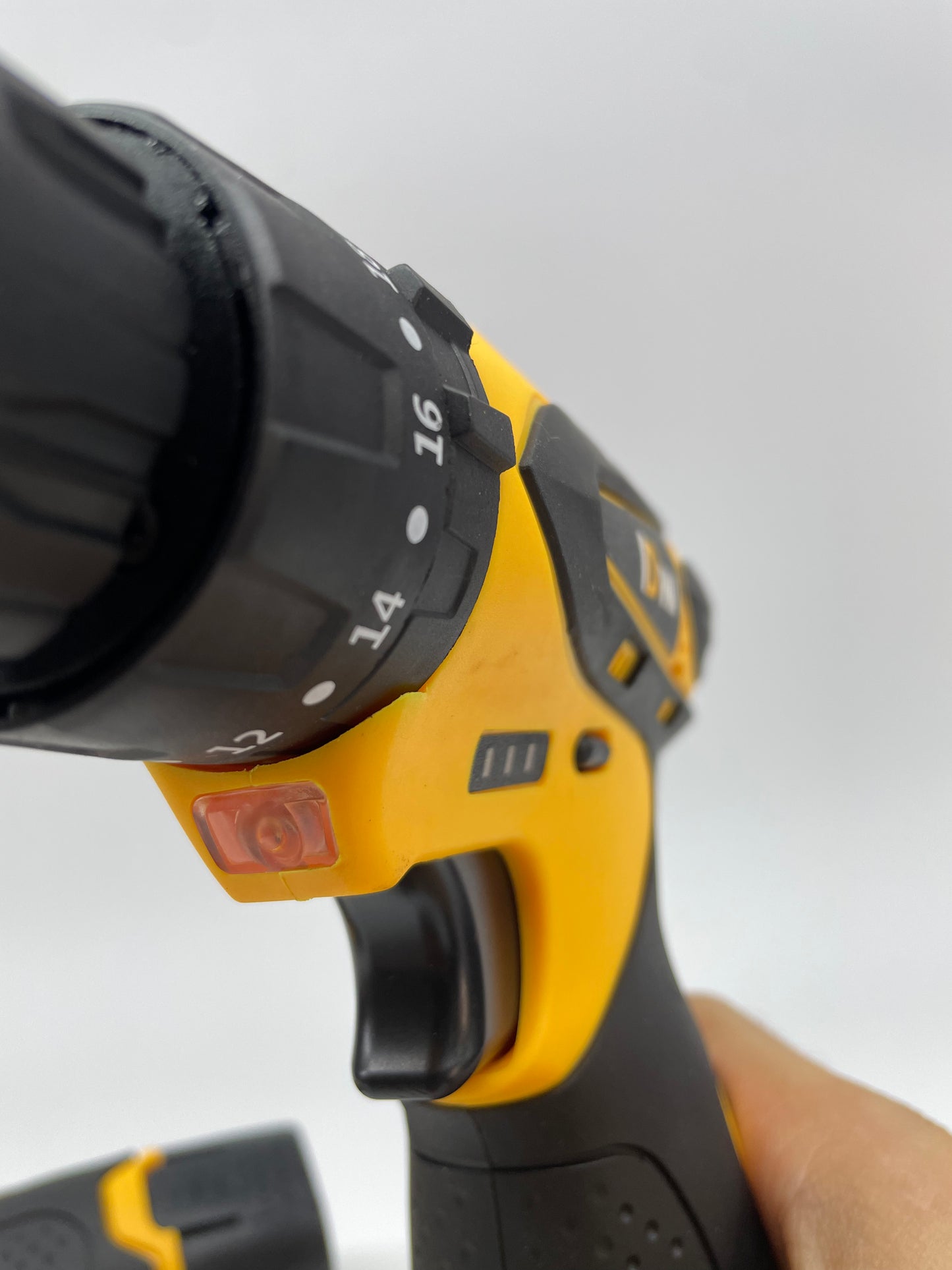 Close-up of a power drill with a focus on the chuck and trigger mechanism.
