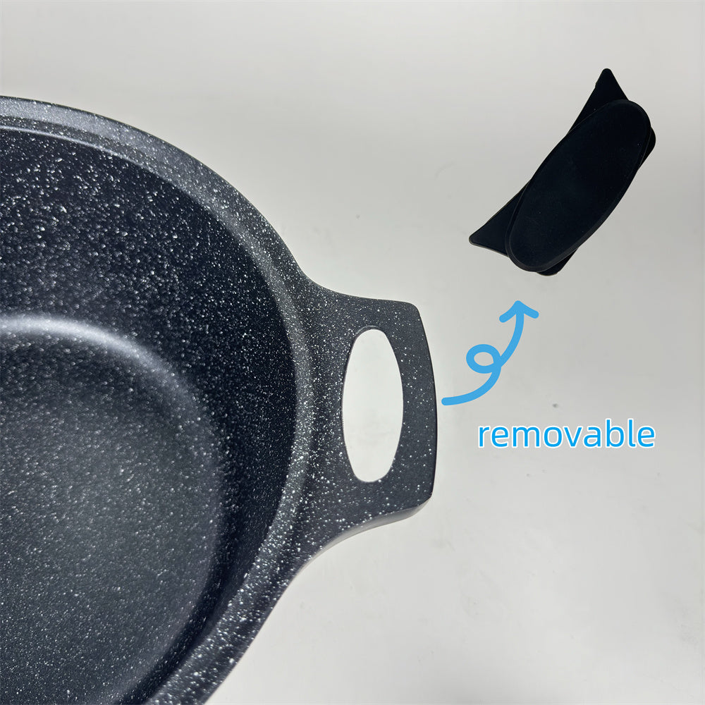 Black speckled frying pan with a removable black handle on a light gray background