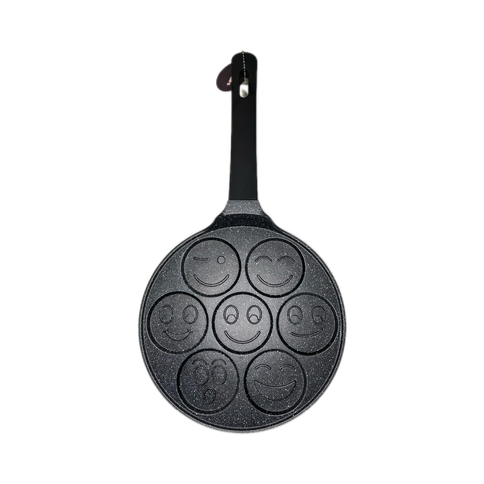 Black pancake pan with smiley face designs on a white background