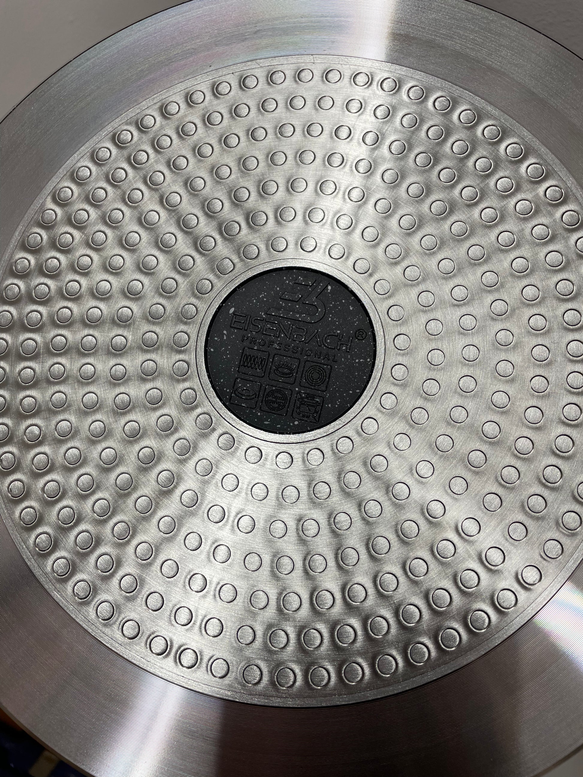 Metallic disc with textured surface and central circular feature