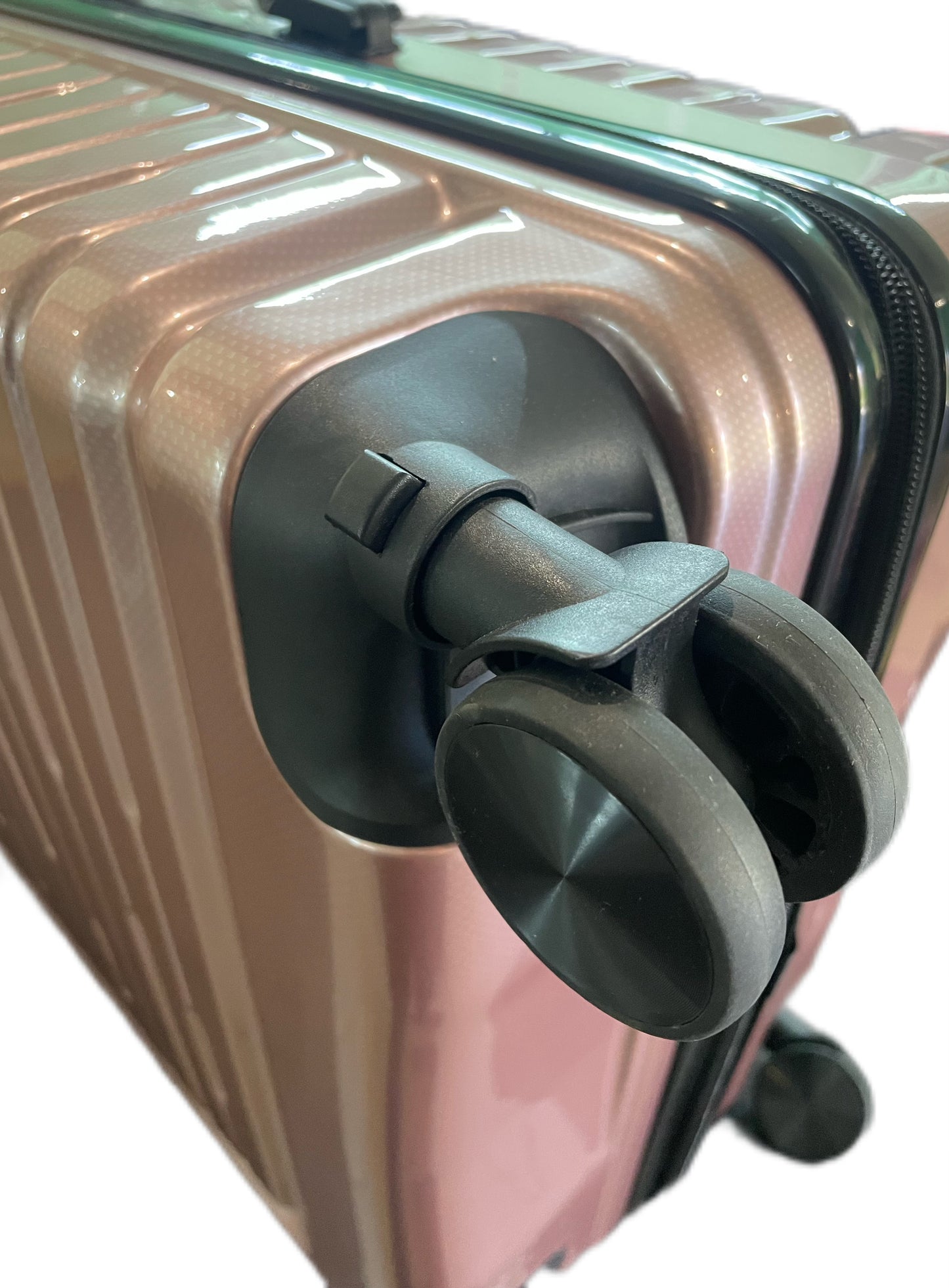 Close-up of a rose gold suitcase with a black wheel on a white background