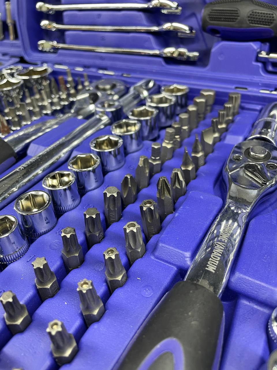 Close-up of a tool set with various sockets and wrenches on a blue tray.