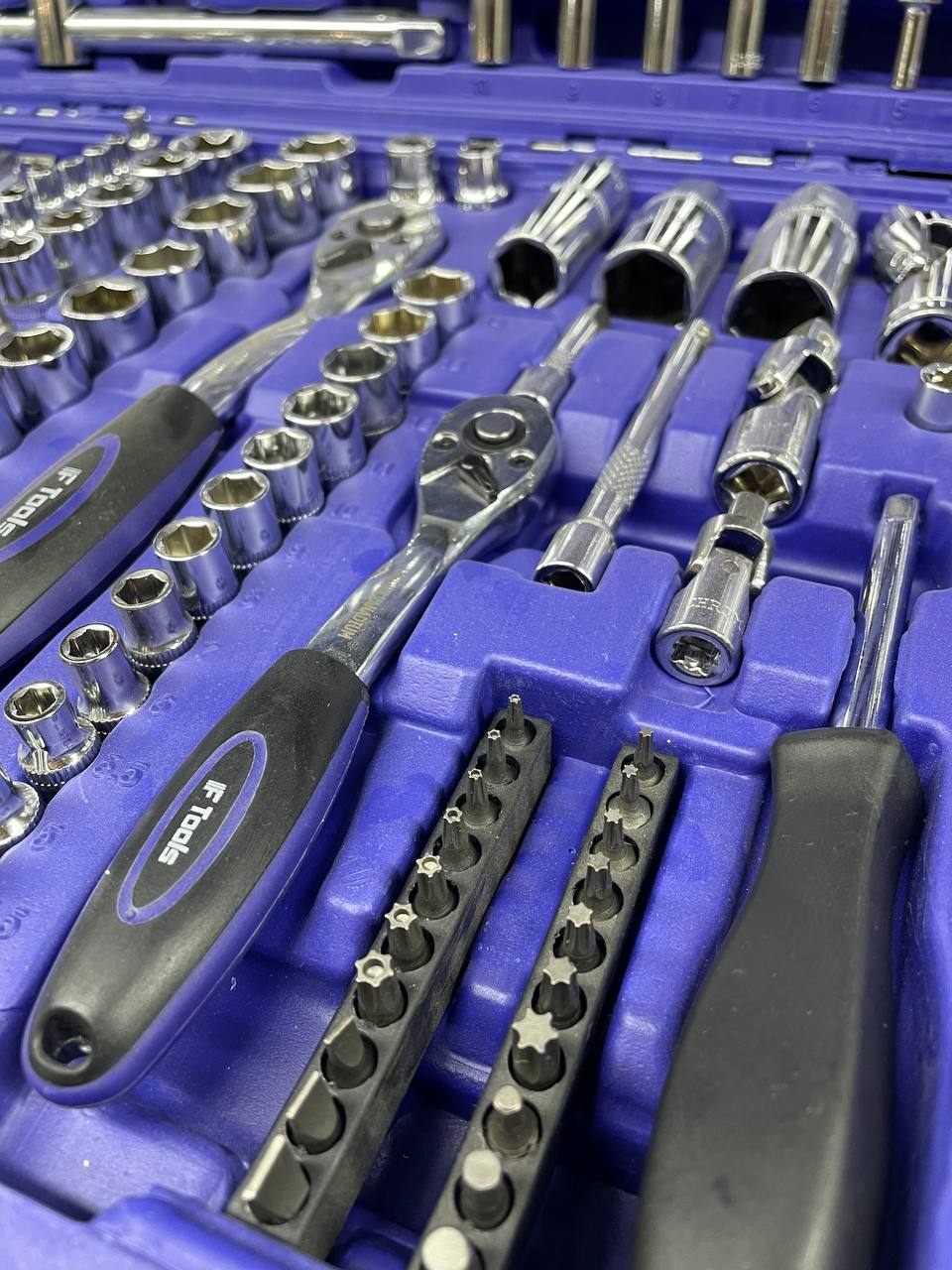 Close-up of a tool set with various sockets and wrenches on a blue tray.