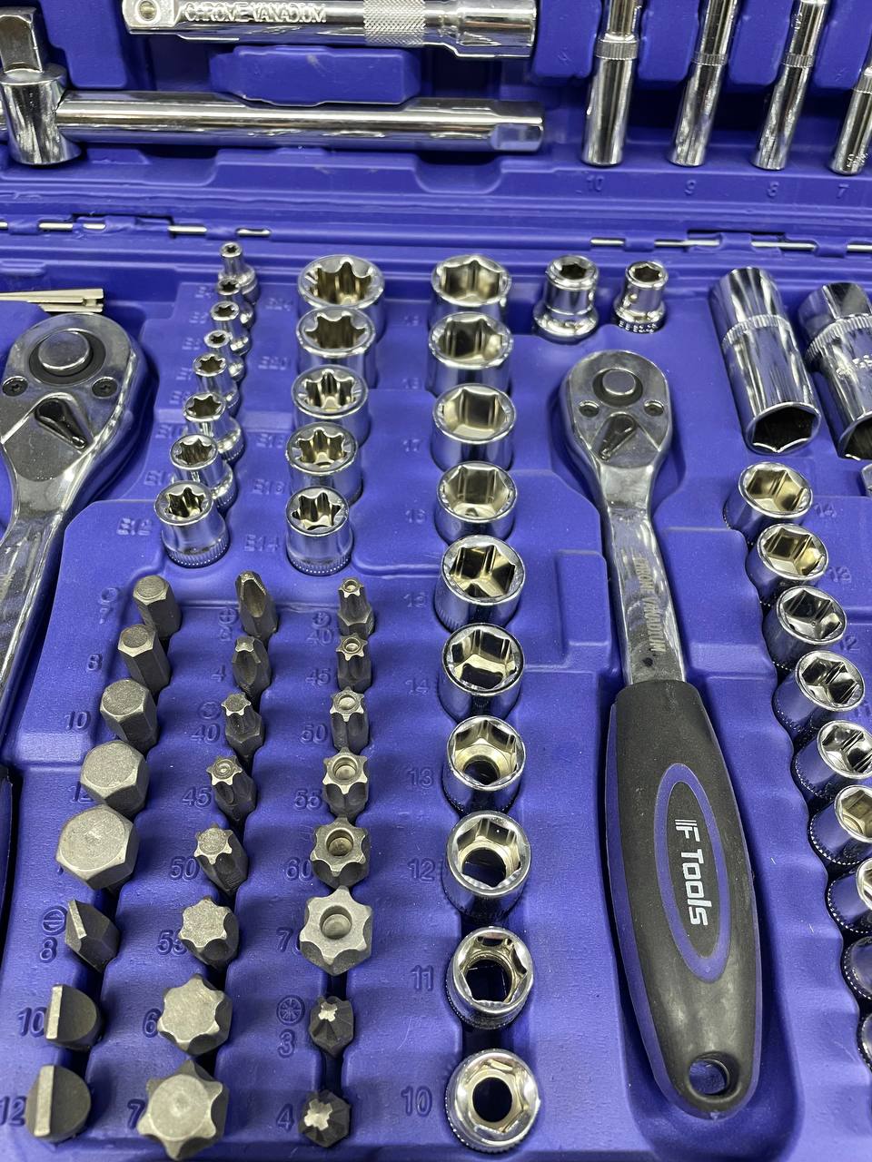 Instrumentu komplekts, ieskaitot uzgriežņu atslēgas un ligzdas uz zilas instrumentu kastes