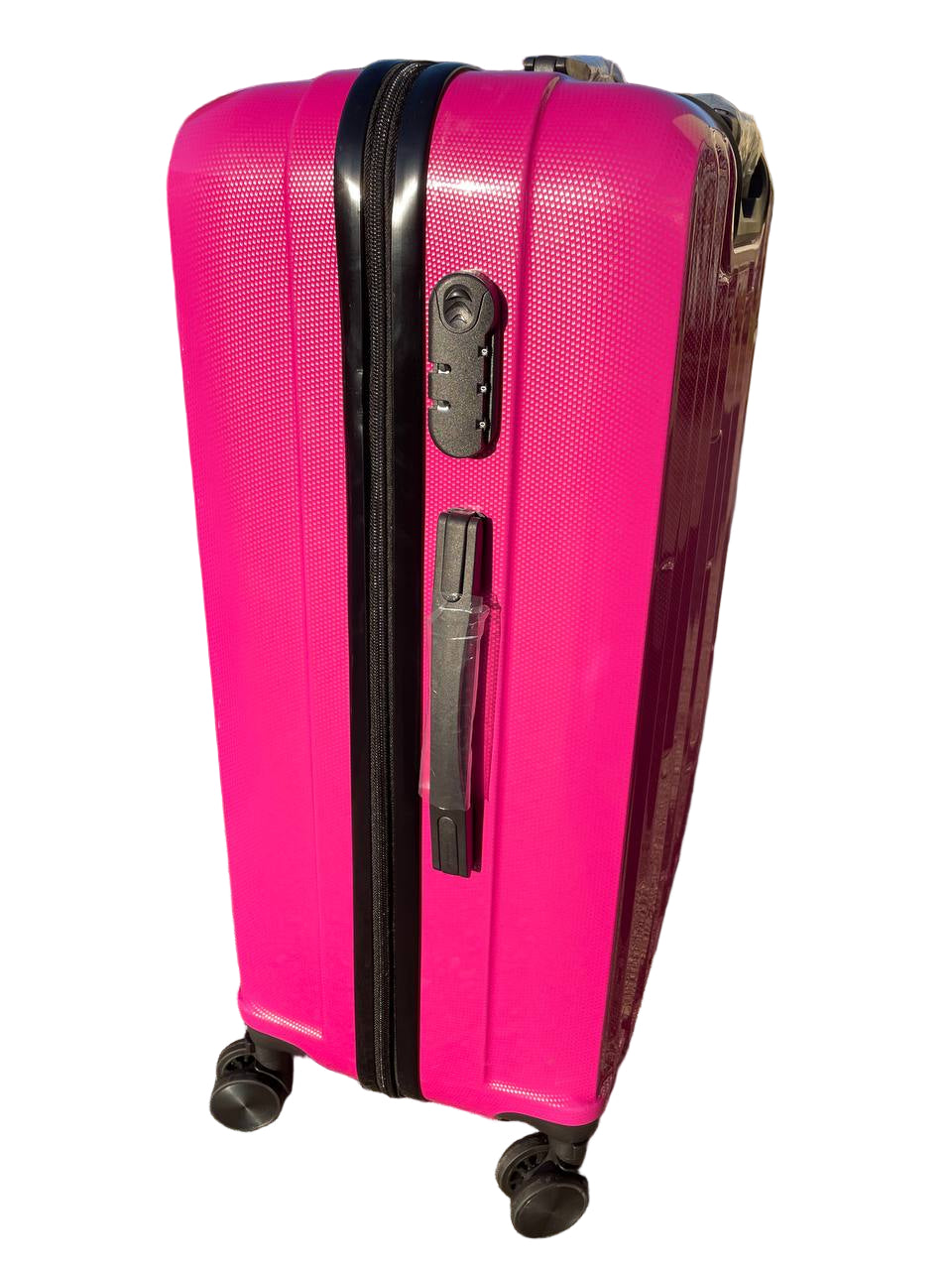 Pink suitcase with black handle and wheels on a pavement