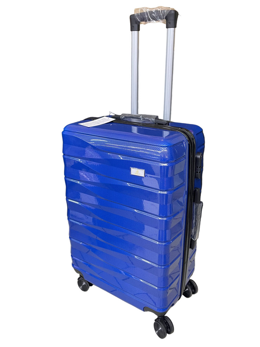 Blue suitcase with wheels on a tiled floor with a black curtain and cardboard box in the background