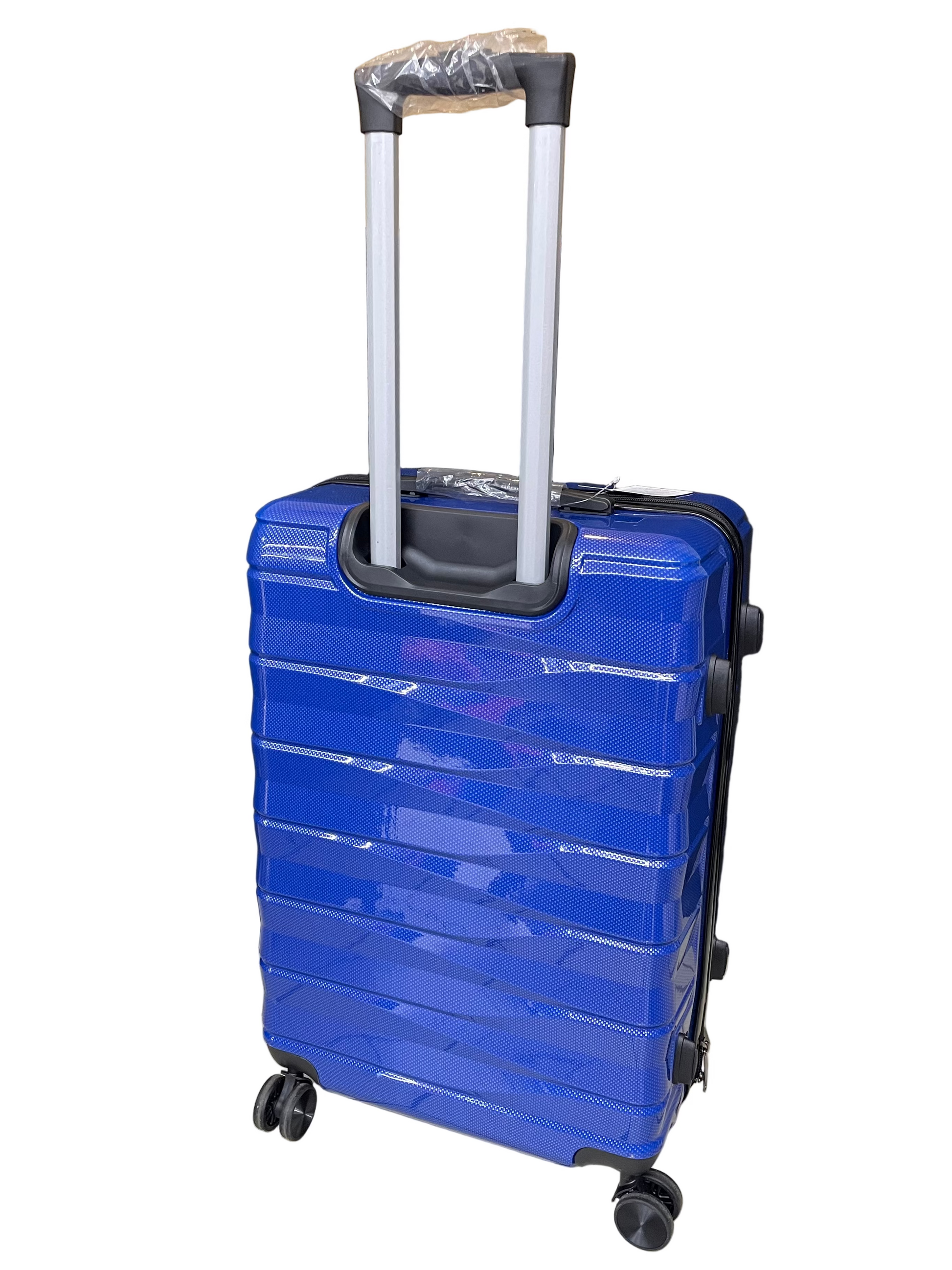 Blue suitcase with a black handle on a tiled floor with a black curtain in the background.