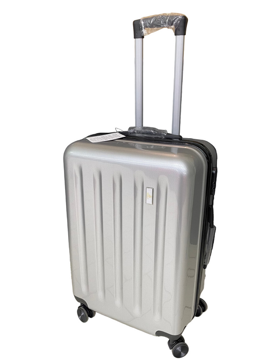 Silver suitcase on a tiled floor with a black curtain in the background