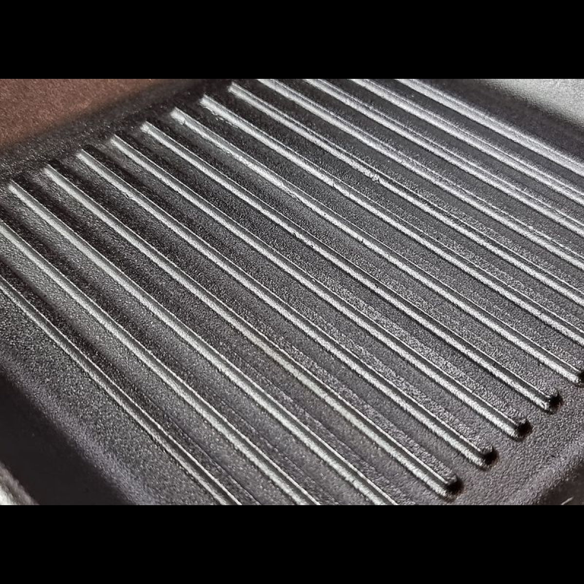 Close-up of a cast iron grill pan with ribbed surface