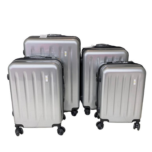 Set of silver suitcases on a tiled floor with a black backdrop